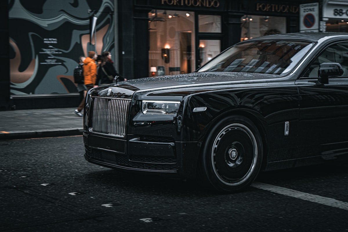 A black Rolls-Royce parked outside a boutique storefront