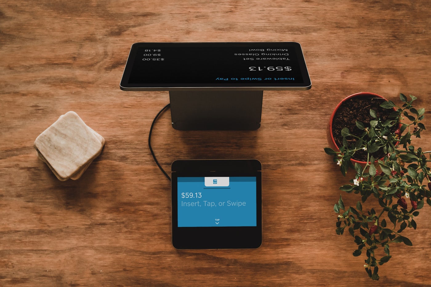 A modern payment terminal on a shop counter